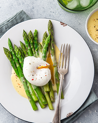 asparagus topped with hollandaise sauce and poached egg